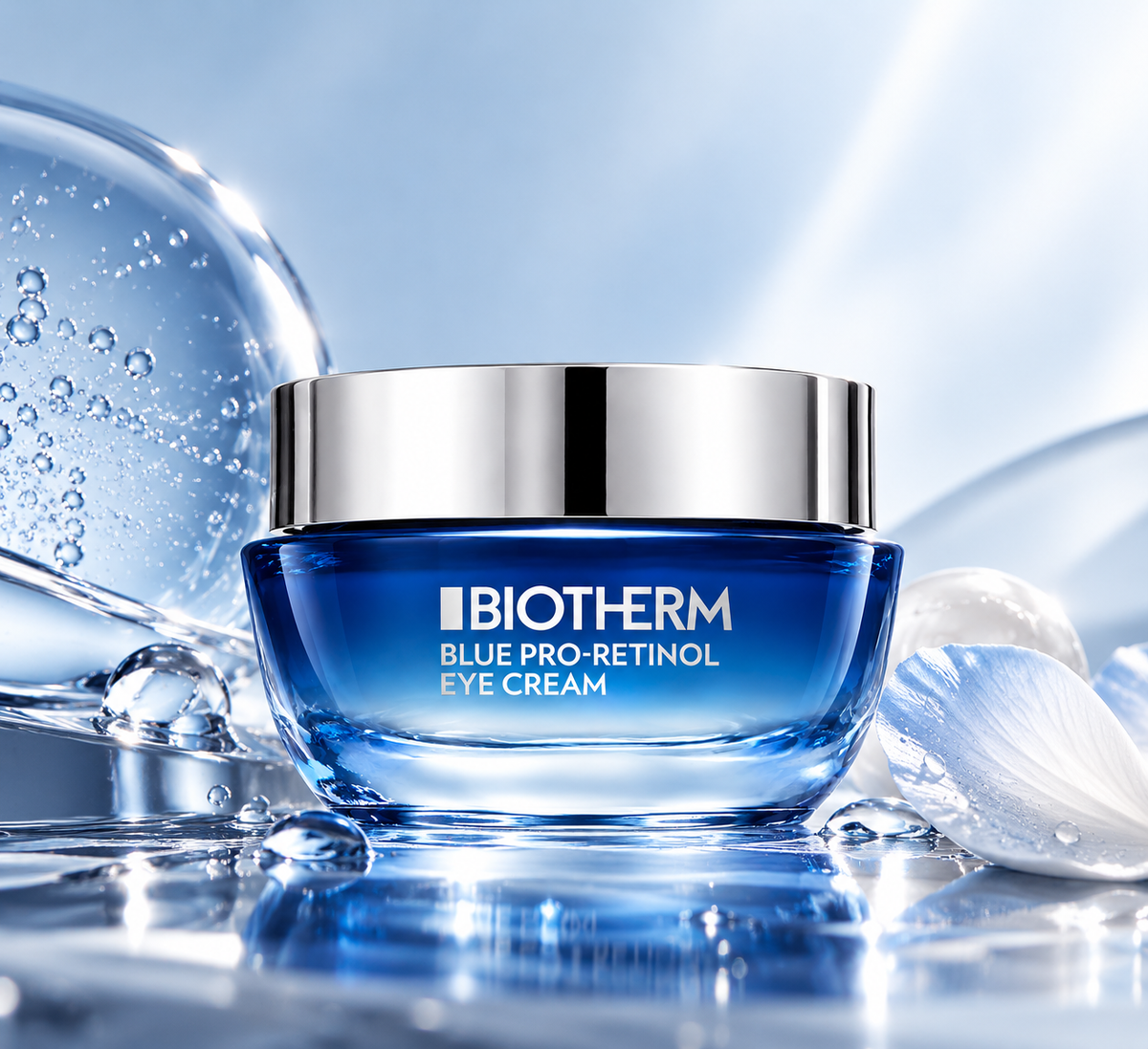 Biotherm Blue Pro-Retinol Eye Cream displayed in a fresh blue skincare setting with water droplets, translucent bubbles and a delicate white petal, creating a hydrating and premium aesthetic.