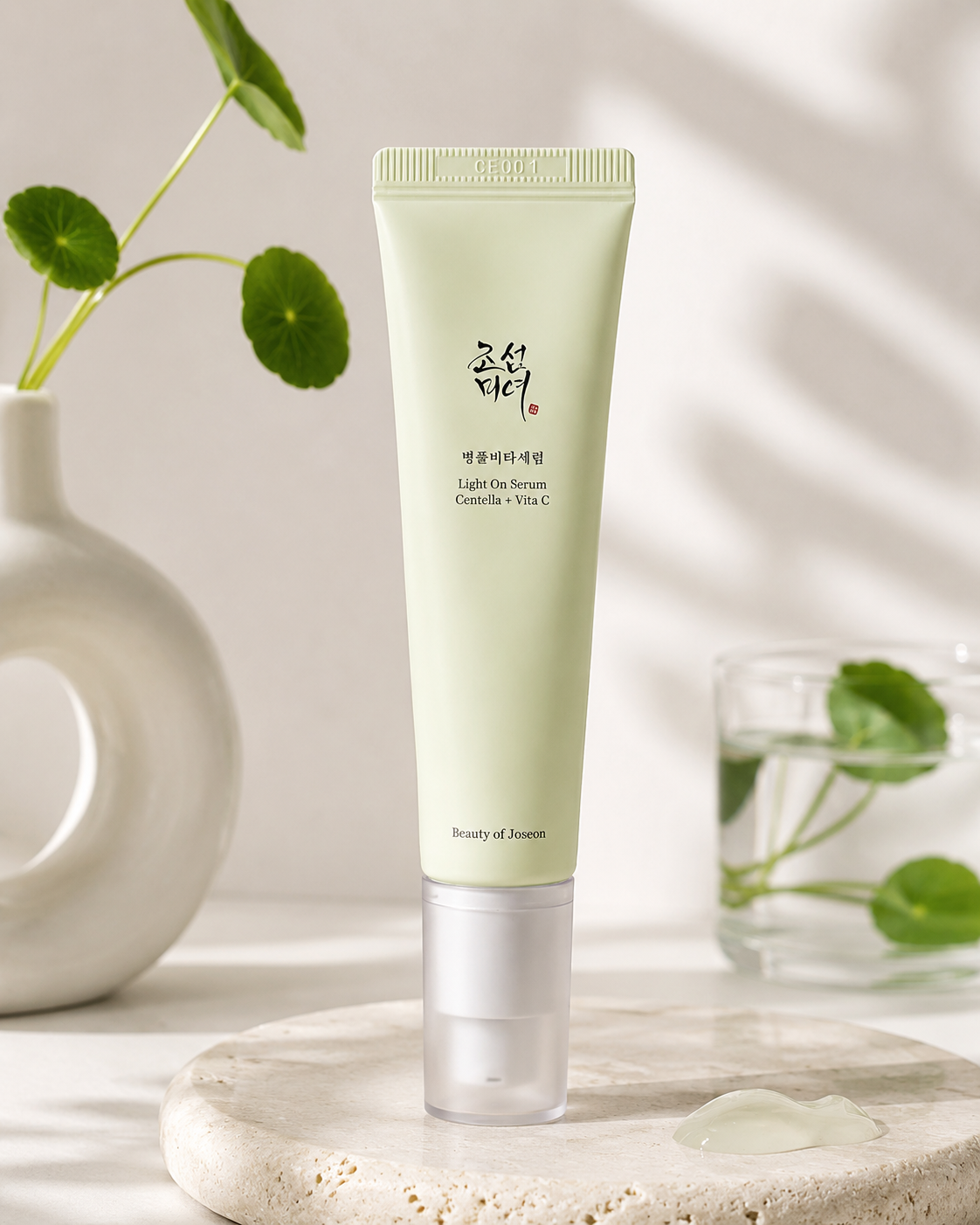 Beauty of Joseon Light On Serum: Centella + Vita C 30ml elegantly displayed on a natural stone tray in a minimalist spa-inspired setting with soft daylight, fresh centella leaves and ceramic décor, highlighting its lightweight gel texture, calming properties and brightening benefits for smooth, glowing and healthy-looking skin.