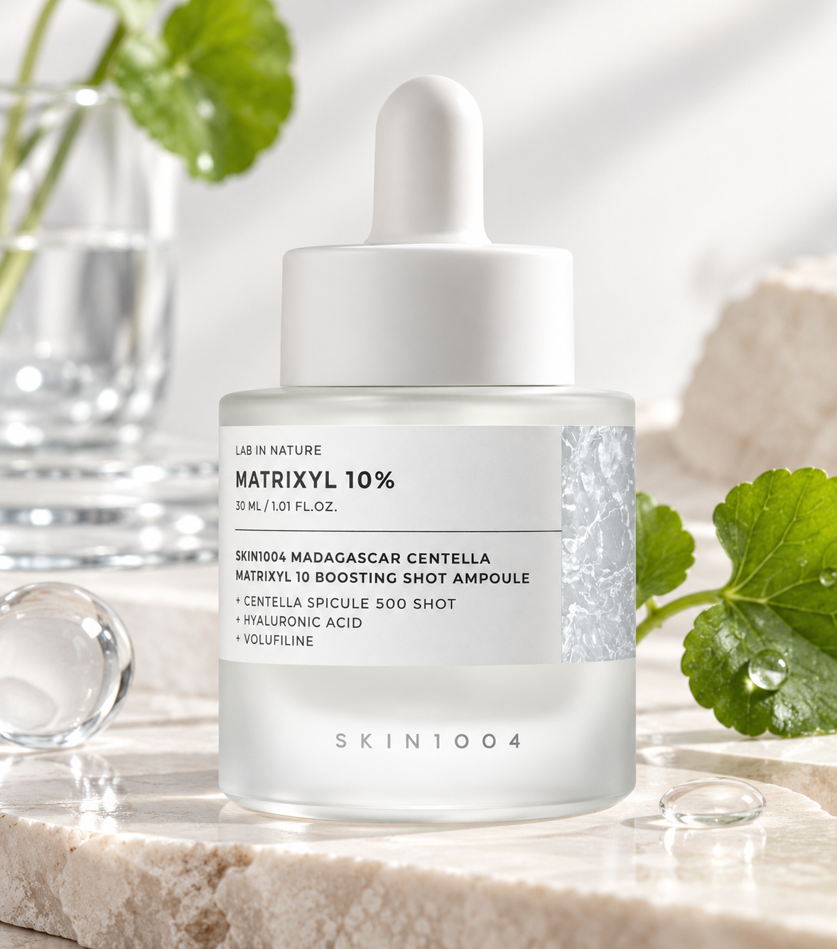 SKIN1004 Madagascar Centella Matrixyl 10 Boosting Shot Ampoule 30ml displayed in a fresh skincare setting with Centella leaves, water droplets, glass accents and natural stone, highlighting its hydrating and skin-boosting formula.